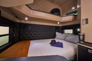 Interior of a Kenworth high-roof sleeper cab featuring a spacious sleeping area and premium driver amenities for long-haul trucking
