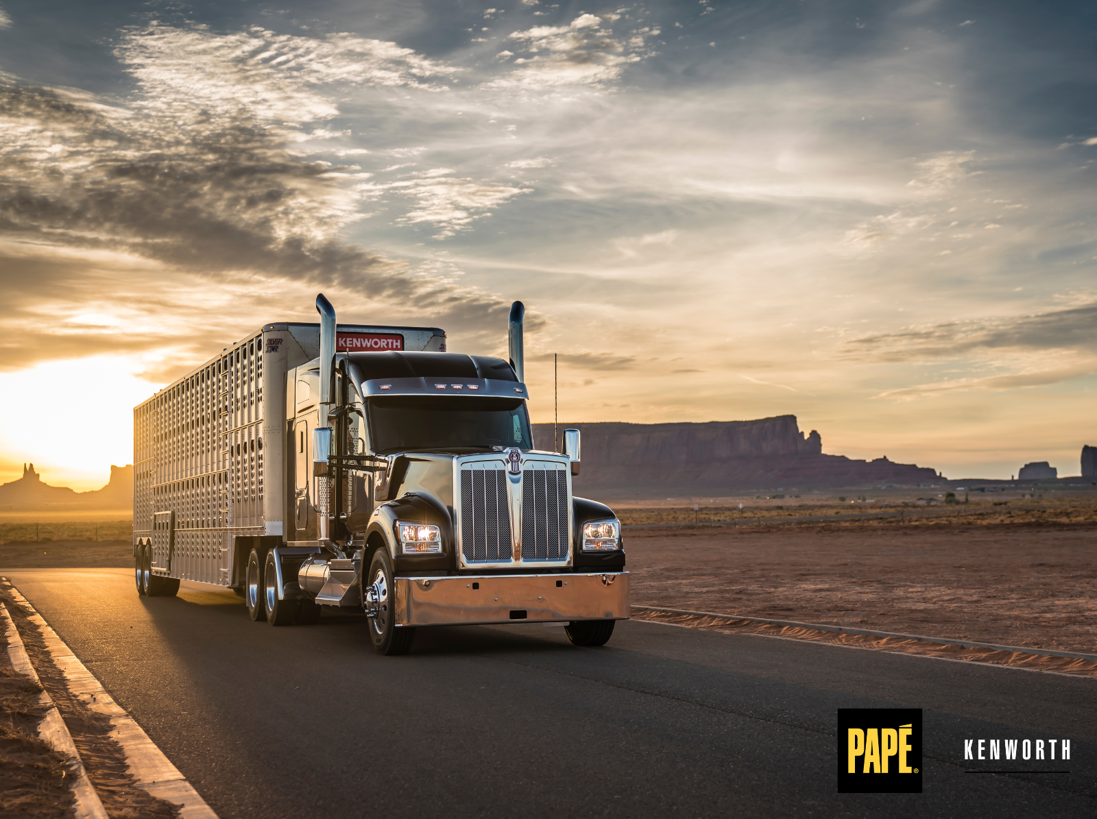 Kenworth W990 sleeper truck hauling a trailer on a long-haul highway route at sunrise