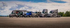 Front view of a Kenworth vocational truck featuring its chrome grille, dual exhaust stacks, and Kenworth badge.