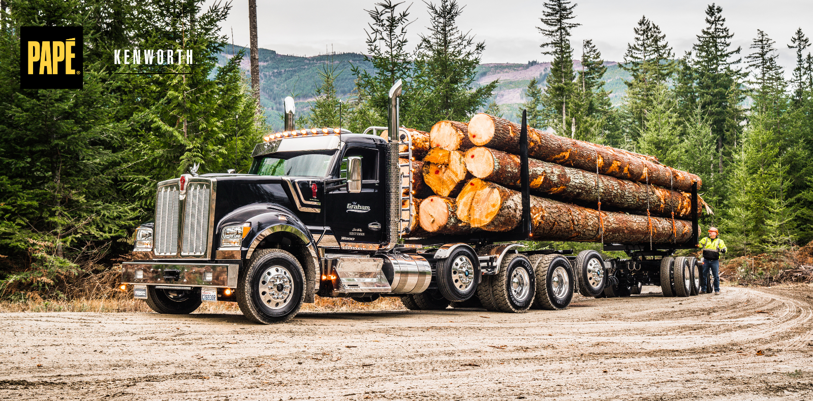 Kenworth logging truck hauling a full load of timber on a forest road.